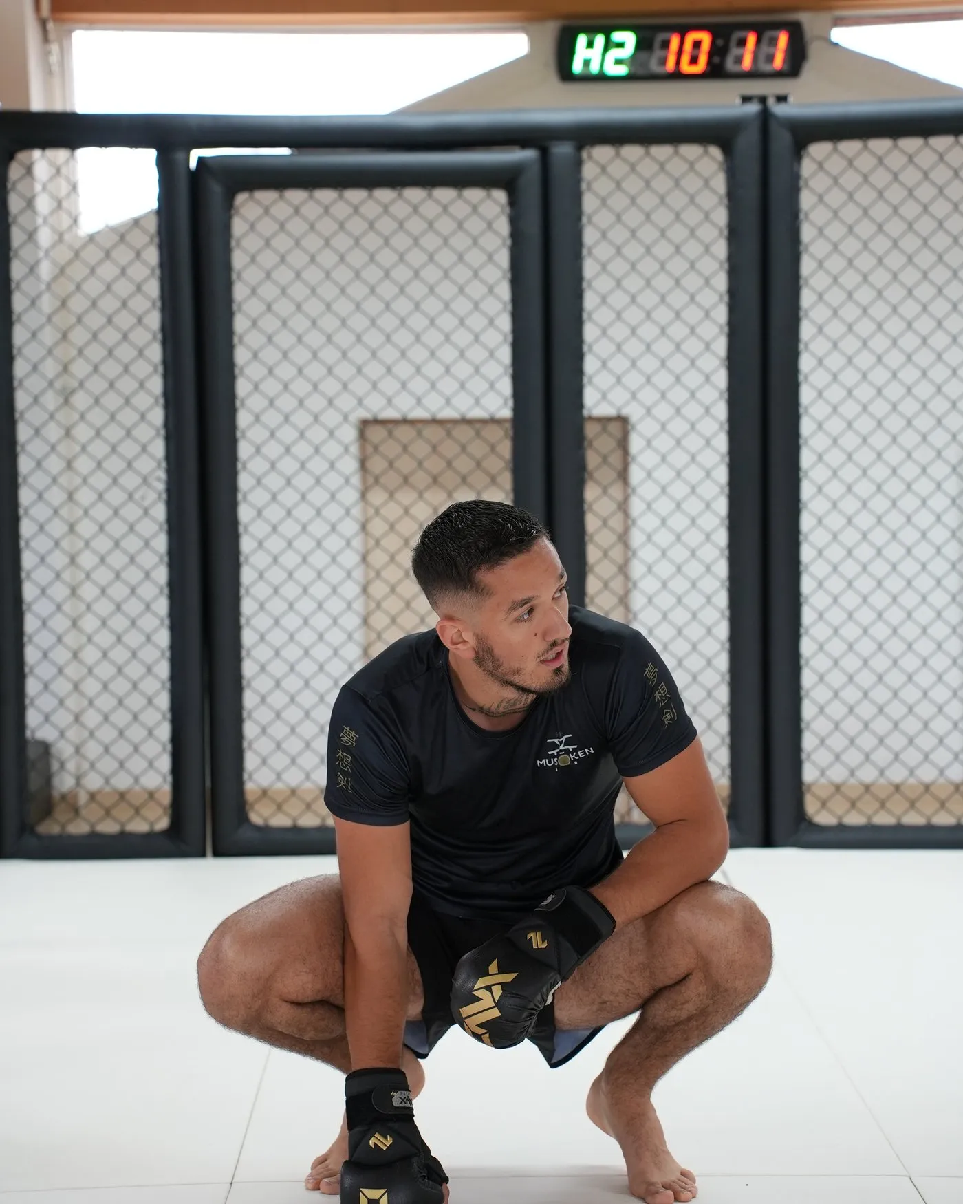 Guillaume Lambelet, coach et fondateur de Musōken, assis sur le tatami devant la cage du dojo
